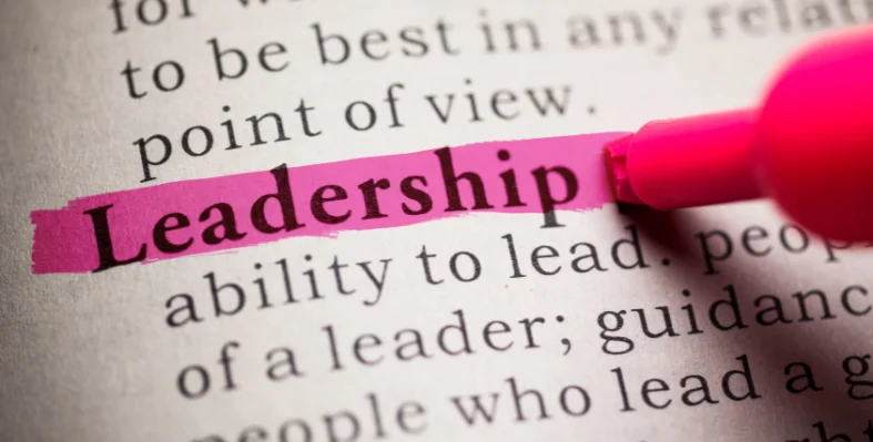 A pink highlighter highlighting the definition of 'Leadership' in a dictionary.