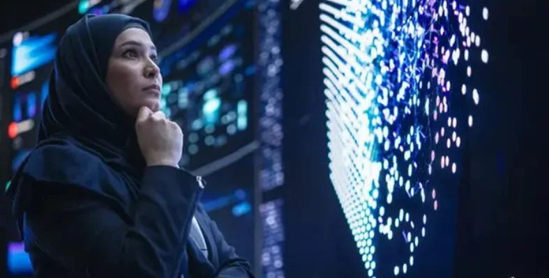 A person in a hijab looking at a digital display screen.