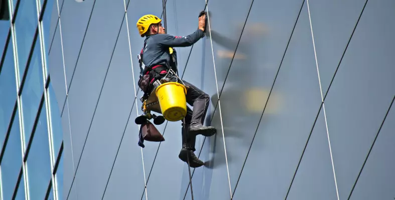 Worker cleaning building. 