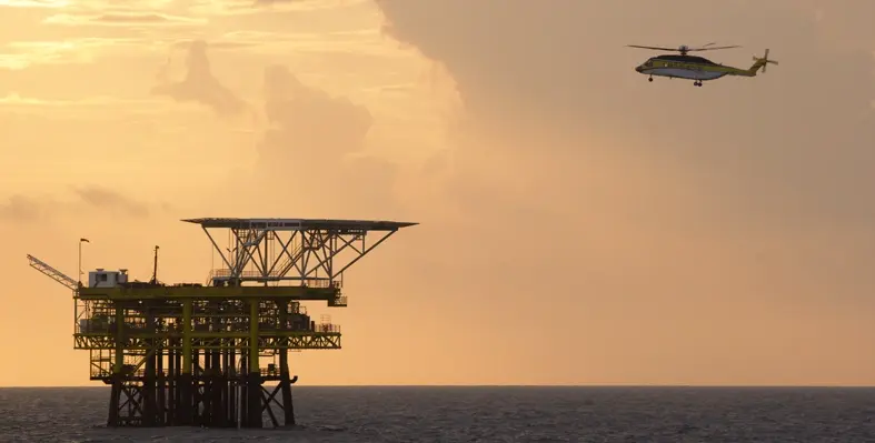 Picture of a helicopter approaching an oil rig