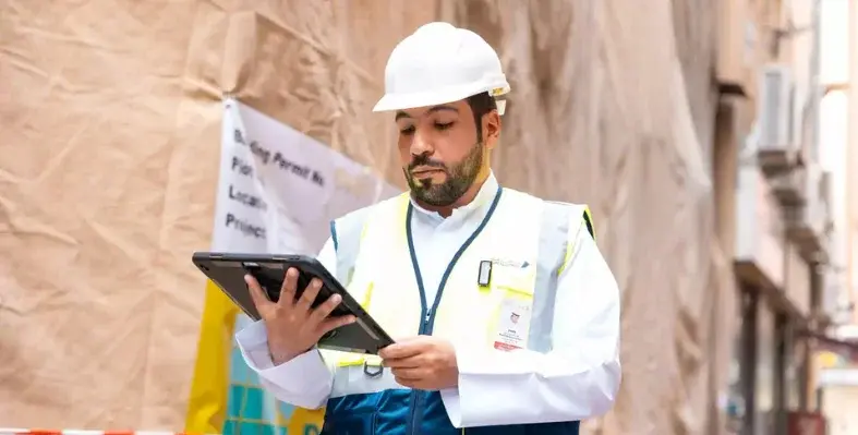 A Dubai safety inspector reflecting on documents.