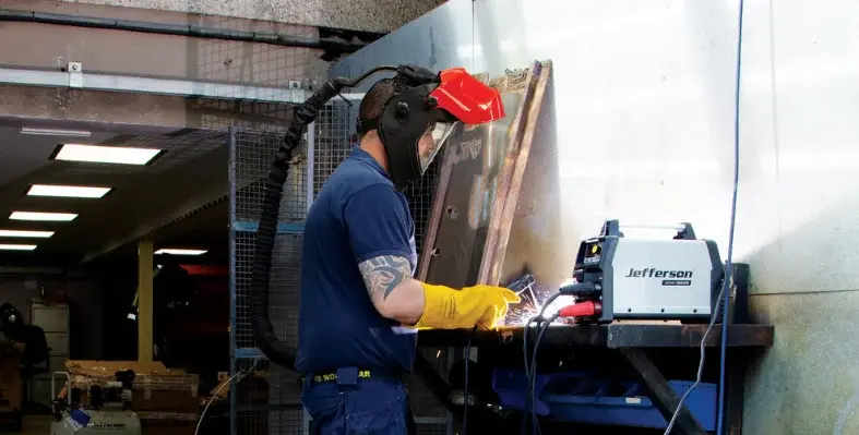 A welder equipped with the Tundra Air Fed Welding Helmet. 