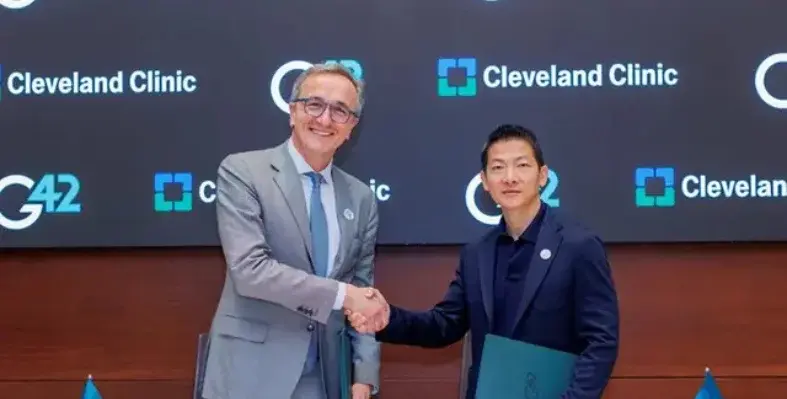 Cleveland Clinic CEO and President Tom Mihaljevic (left) shaking hands with Peng Xiao, G42's group CEO (right) at the signing agreement for the companies' joint AI taskforce.